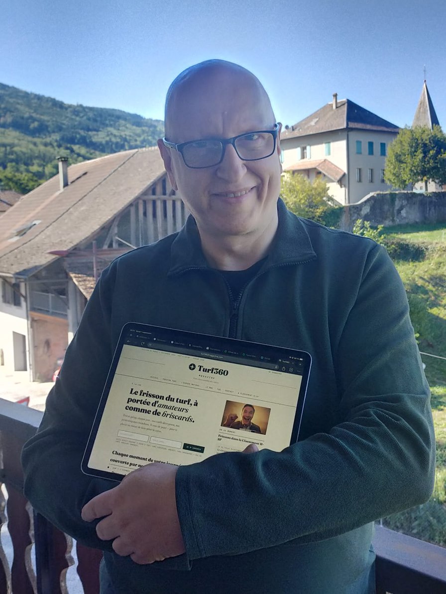 Georges, co-fondateur et éditeur technique de Turf360 Magazine, tenant une tablette affichant le site
